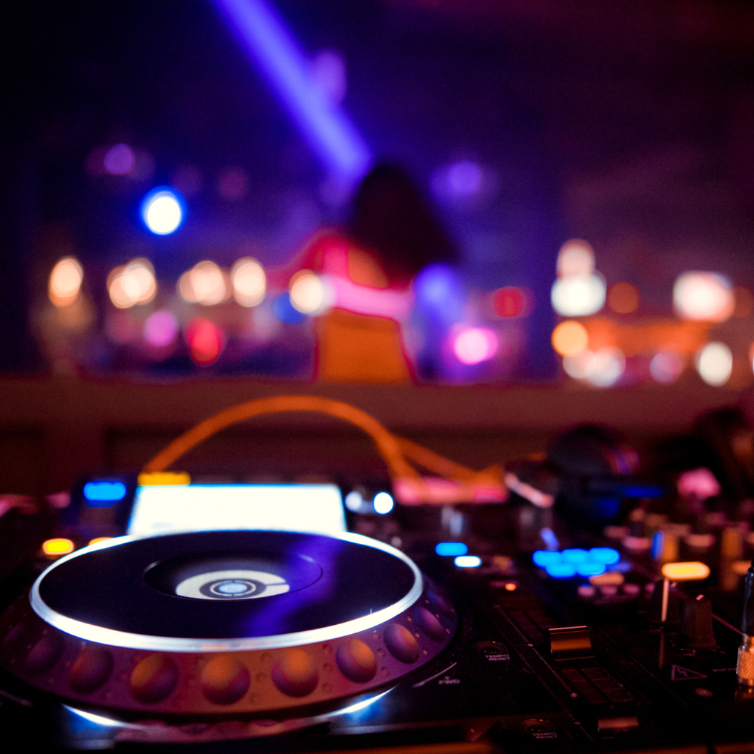 A dj 's turntable is lit up in a dark room