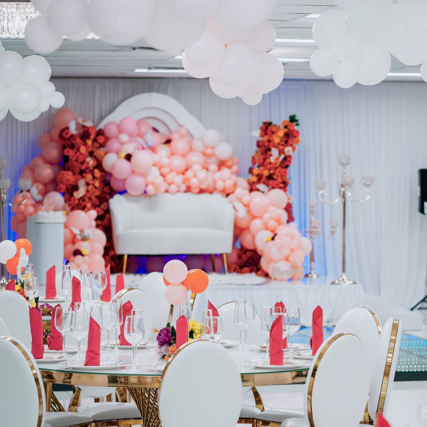 A room with tables and chairs and balloons on the ceiling