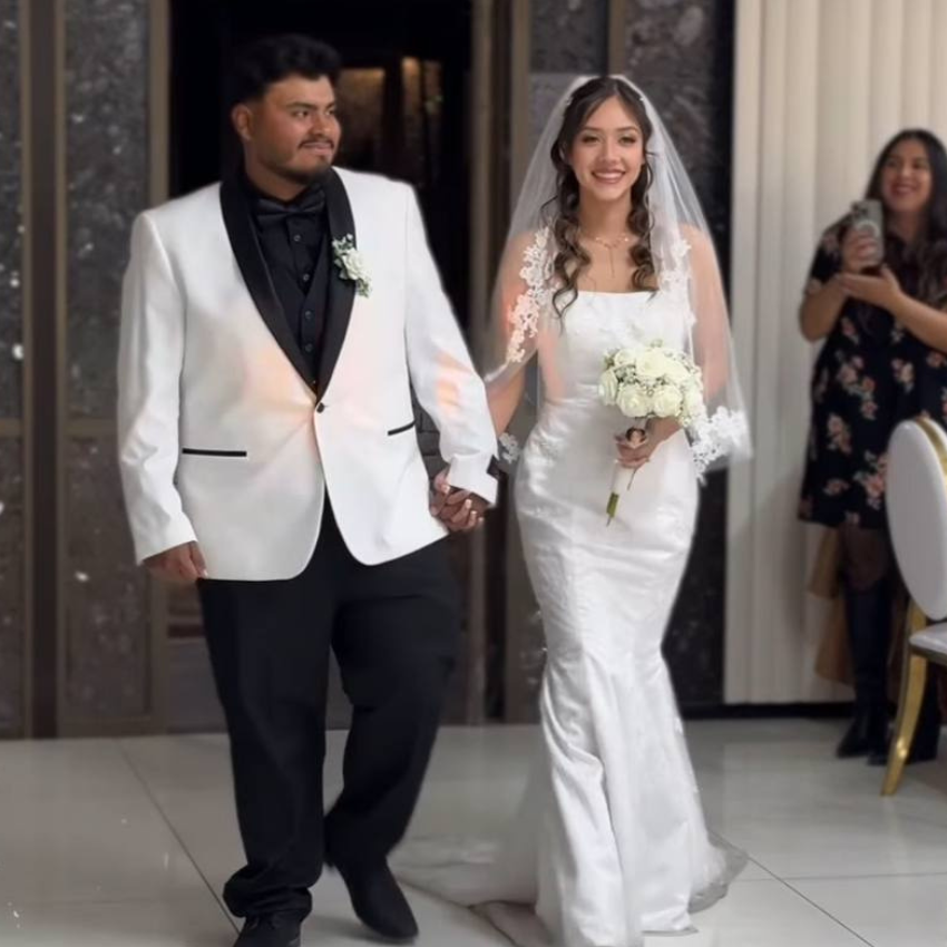 A bride and groom are walking down the aisle holding hands