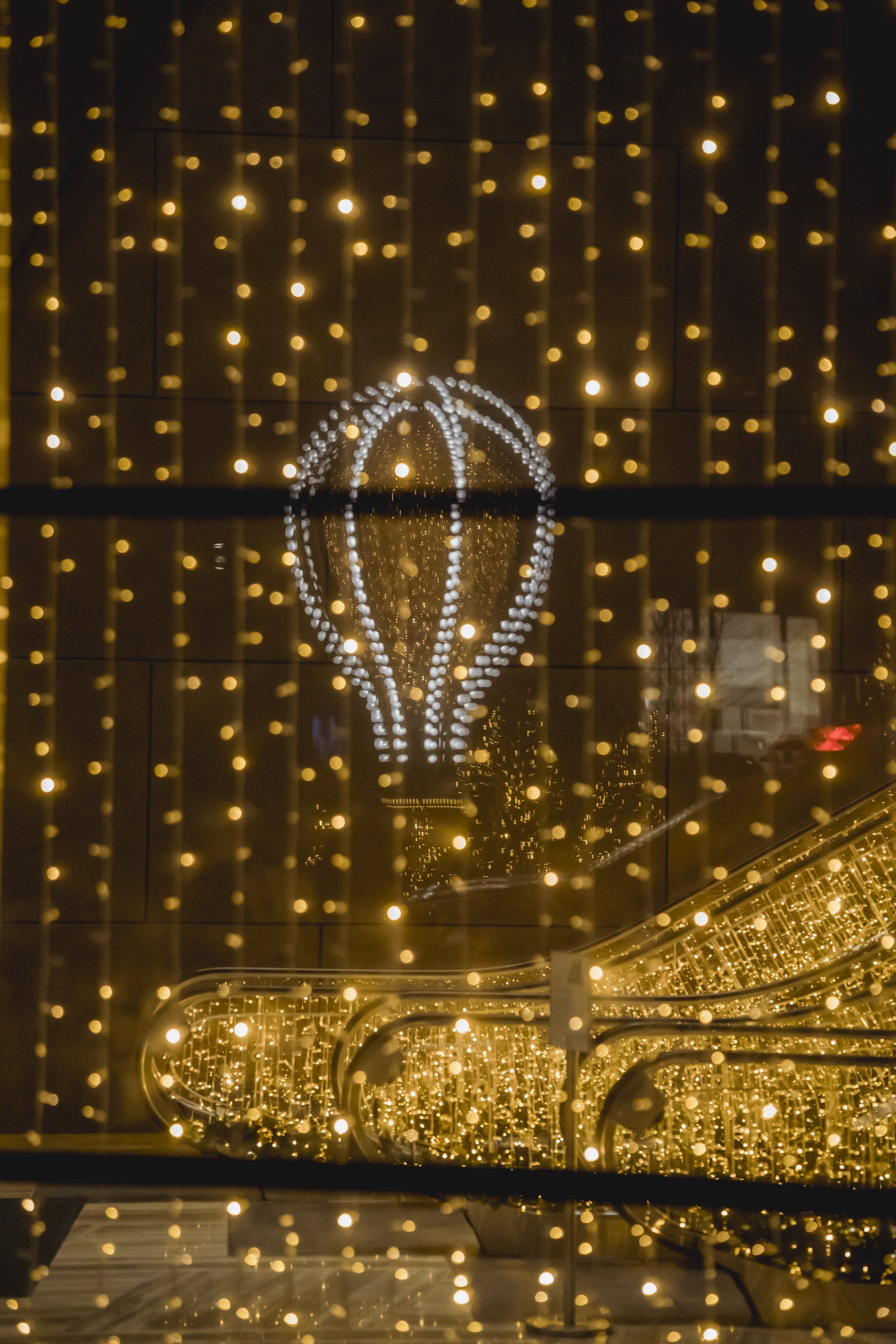A hot air balloon is hanging from a curtain of lights.