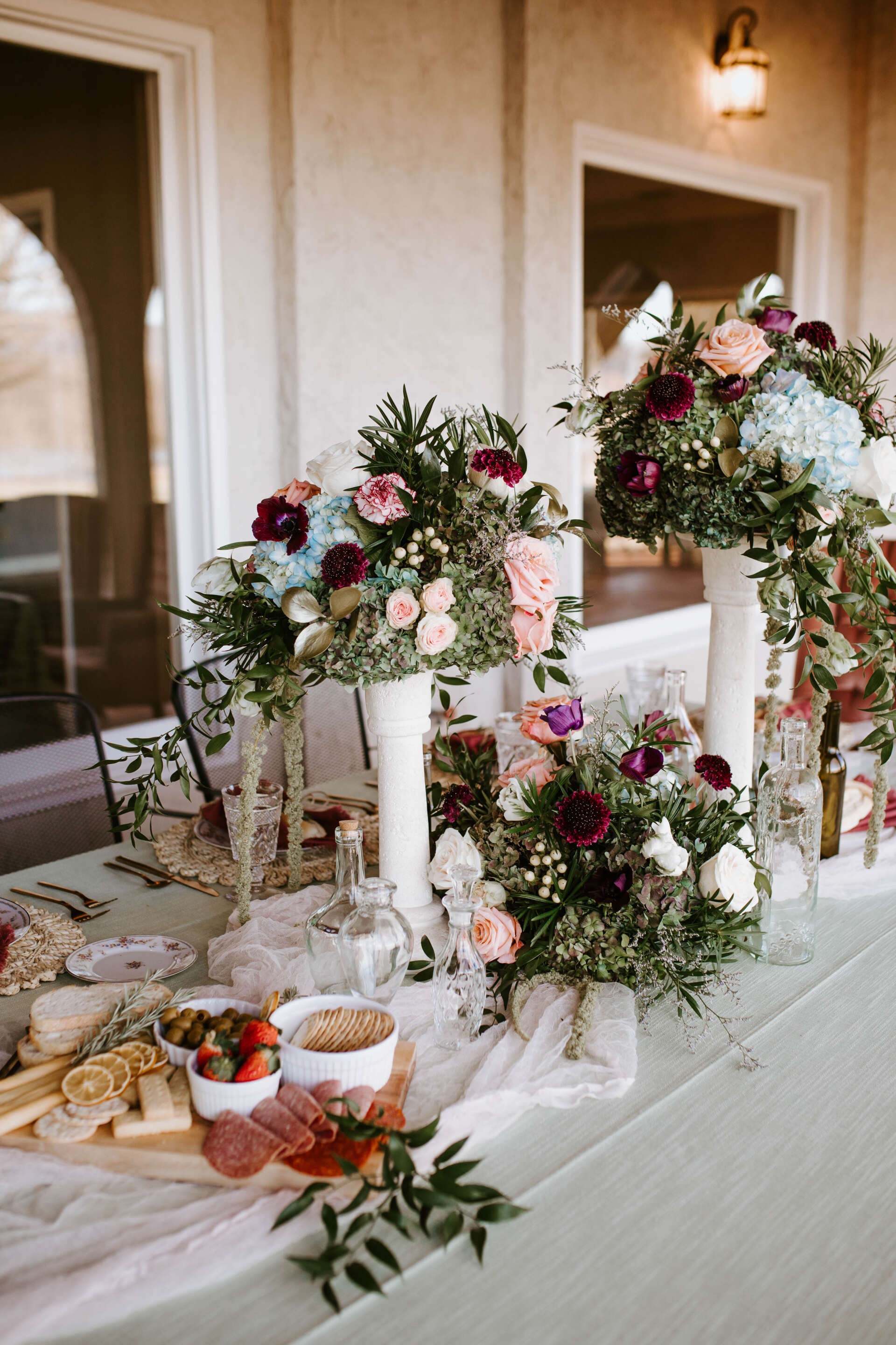 A long table with flowers and food on it.