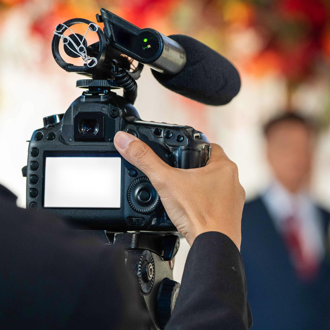 A person is holding a camera with a microphone attached to it.